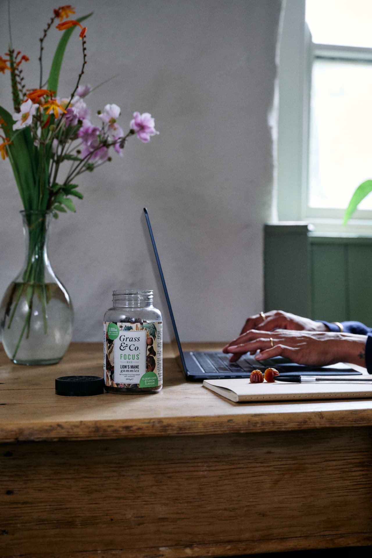 FOCUS MAX gummies jar on a desk beside someone typing