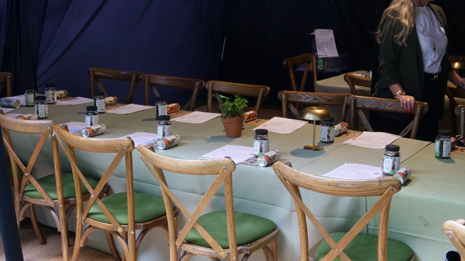Long tables laid with worksheets, Grass & Co. FOCUS jars and cans before the workshop begins